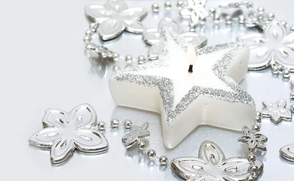 Белая свеча с серебряными цветами — стоковое фото