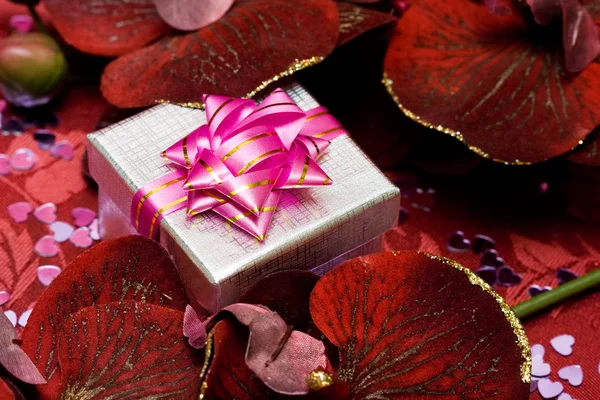 Presentförpackning med röda blommor — Stockfoto