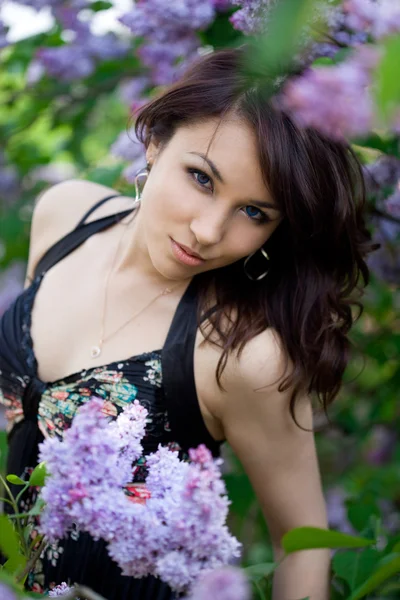 Inschrijving meisje in de tuin met lila — Stockfoto