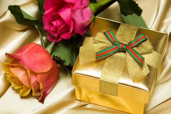 Caixa de presente com rosas vermelhas e amarelas — Fotografia de Stock