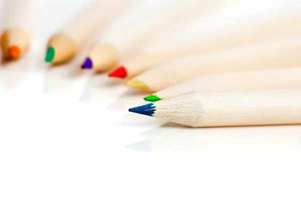 Many colored pencils in row over white background — Stock Photo, Image