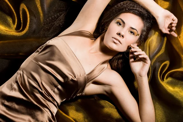 Sexy modieuze vrouw in een gouden jurk — Stockfoto
