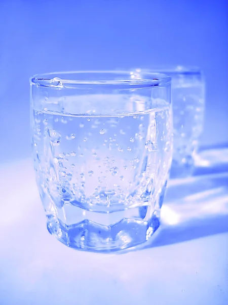 Vidrio con agua en color azul — Foto de Stock