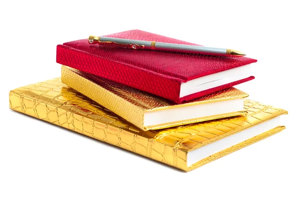 Zlaté a červené notebooky s stříbrným perem — Stock fotografie