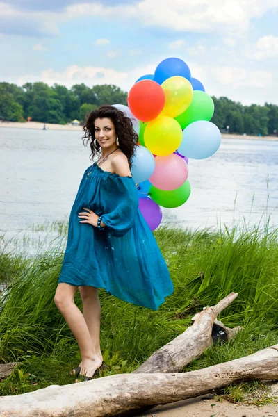 Счастливая женщина с цветными воздушными шарами — стоковое фото