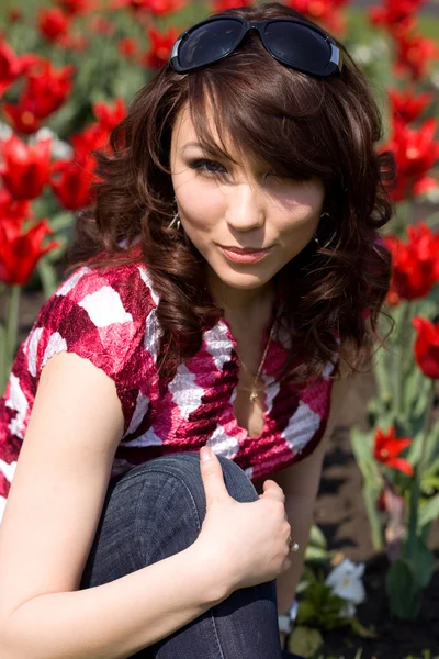 Menina macia no jardim com tulipas — Fotografia de Stock