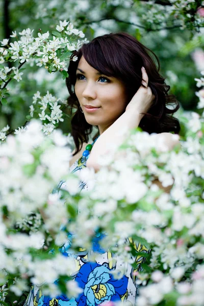 Pályázati lány a kertben virágkocsányon fák — Stock Fotó