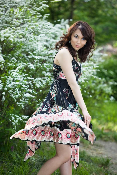 Chica tierna en el jardín con árboles de flores — Foto de Stock