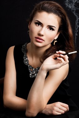 Beautiful woman smokes a cigarette clipart