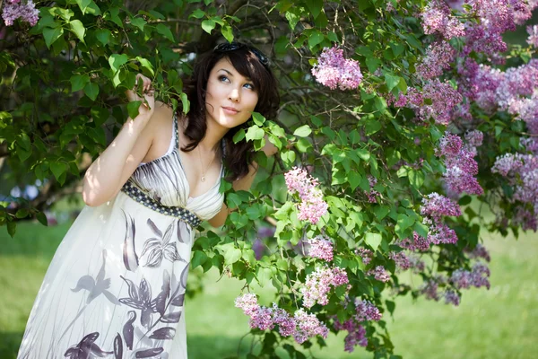 Chica tierna en el jardín con lila —  Fotos de Stock