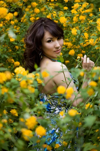 Tender girl in the garden with flowers — Stock Photo, Image