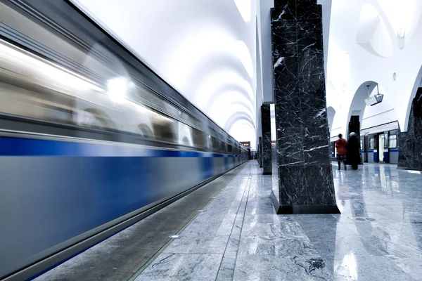 Undeground platfom with columns and moving train — Stock Photo, Image