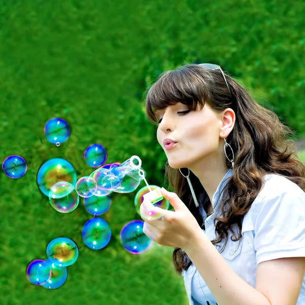 Menina soprando bolhas na primavera — Fotografia de Stock