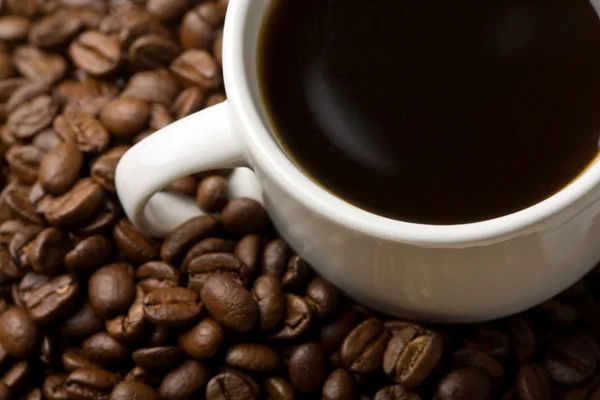Weiße Tasse Kaffee und Kaffeebohnen — Stockfoto