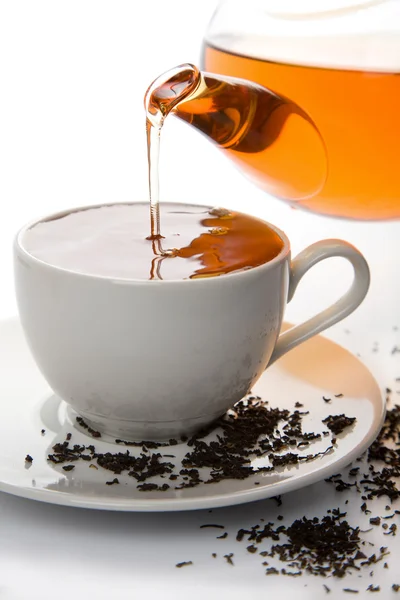 Tea pouring into white cup isolated — Stock Photo, Image