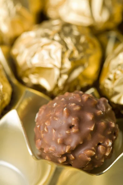 Chocolate candies over golden background — Stock Photo, Image