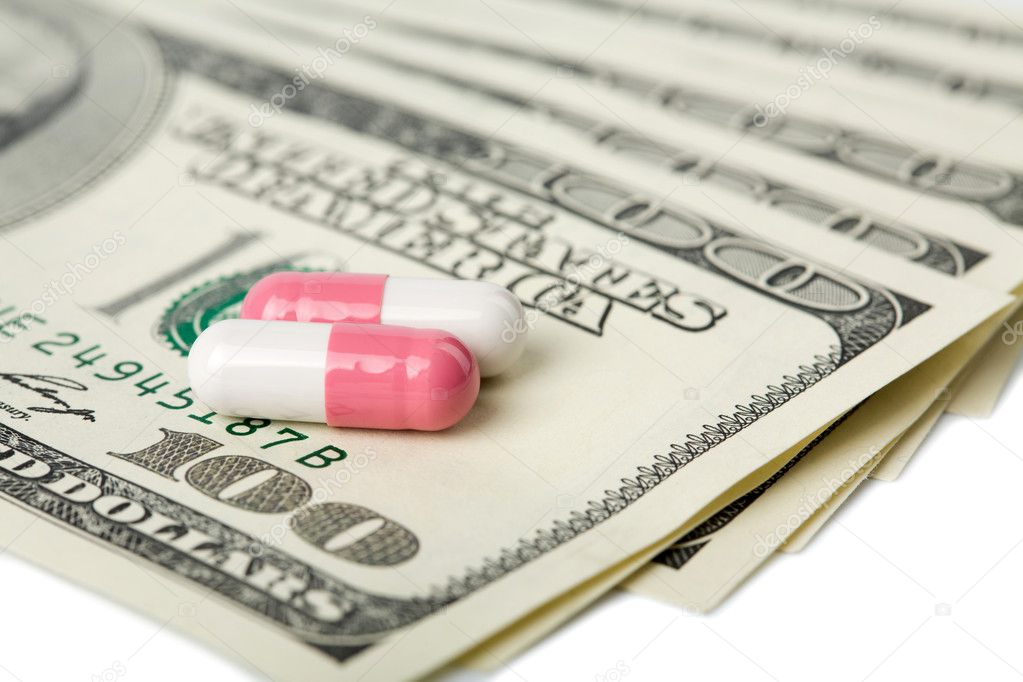 Capsule pills over dollar banknotes