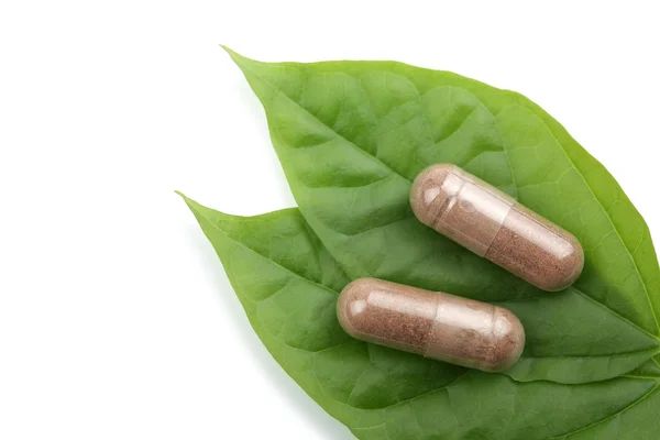 Macro of prescription pills over green leaf — Stock Photo, Image