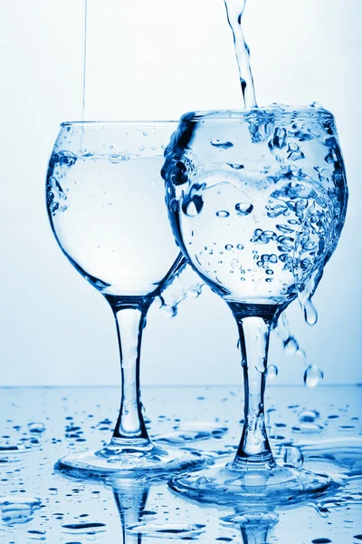 Pure water pouring into glasses — Stock Photo, Image