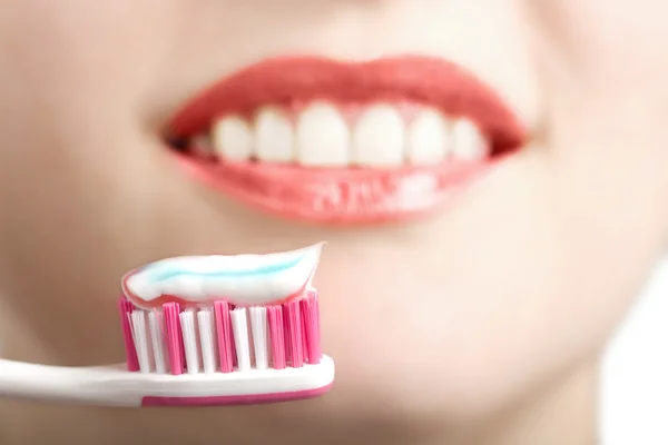 Cepillo de dientes y sonrisa blanca. centrarse en el cepillo de dientes —  Fotos de Stock