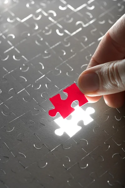 Hand holding red puzzle piece — Stock Photo, Image