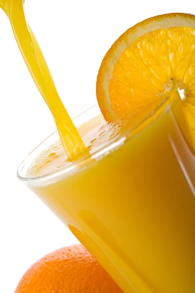 Orange juice pouring into glass isolated — Stock Photo, Image