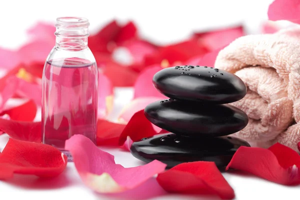 Piedras de zen, aceite esencial y pétalos de rosa aislados —  Fotos de Stock