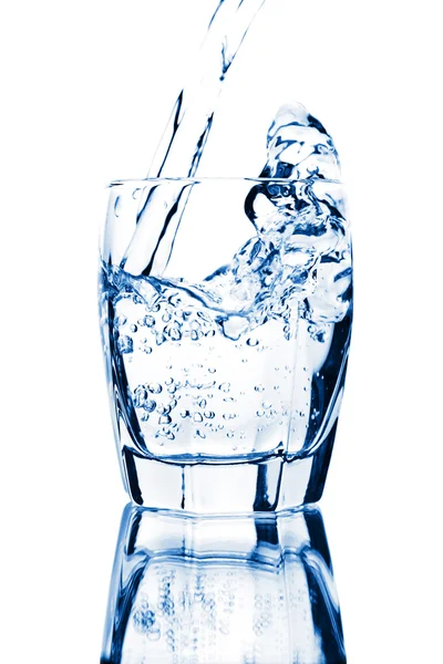 Wasser spritzt isoliert ins Glas — Stockfoto