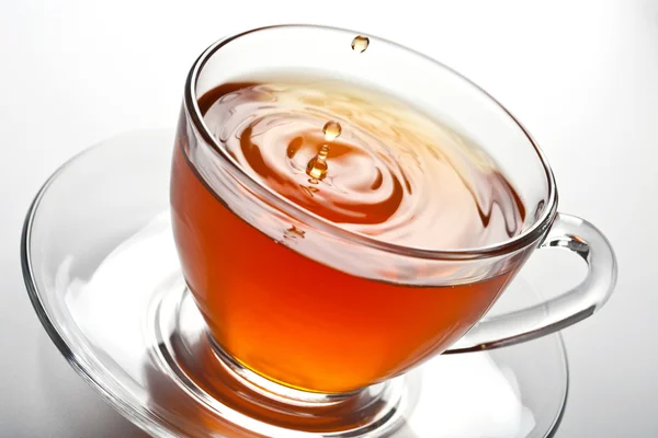 Брызги чая в стеклянной чашке — стоковое фото