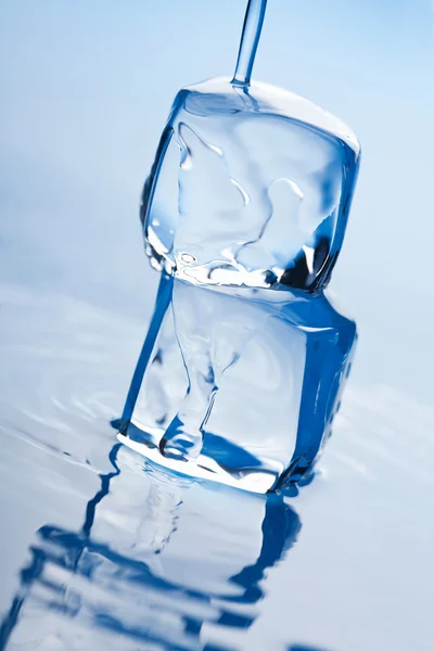 Wasser spritzt über Eiswürfel — Stockfoto