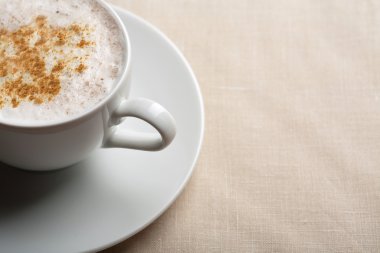 kapuçino keten arka plan üzerinde beyaz fincan