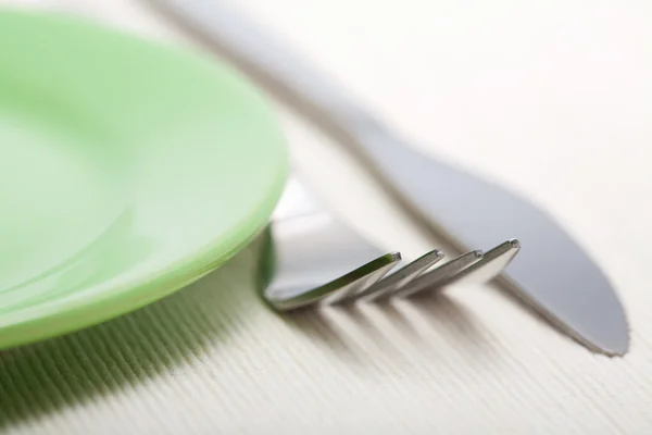 Gaffel och kniv nära gröna plattan — Stockfoto