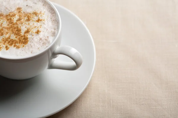 Cangkir putih cappuccino di atas latar belakang linen — Stok Foto