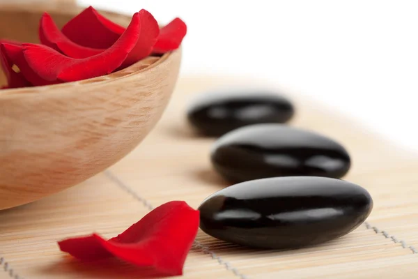 Spa stones and rose petals in bowl isolated — Stock Photo, Image