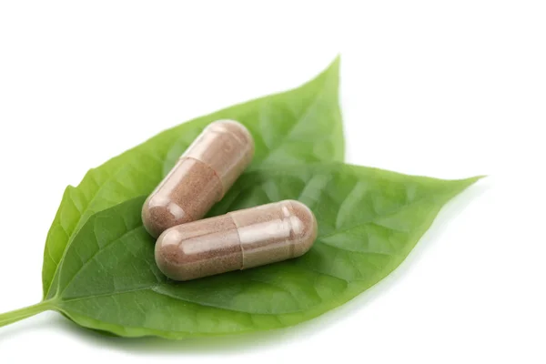 Macro of prescription pills over green leaf isolated — Stock Photo, Image