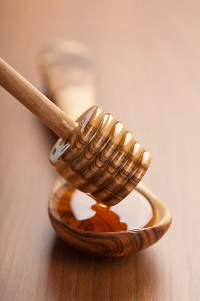 Vild honung hälla i trä sked från skopa — Stockfoto