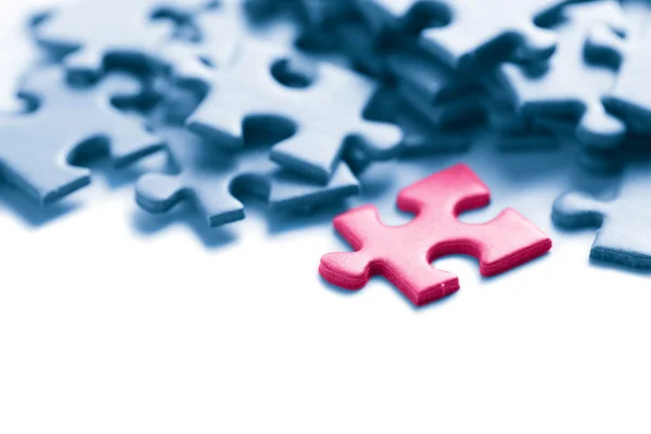 Blue puzzle with one pink piece — Stock Photo, Image