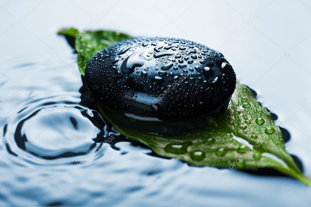 Spa stone on leaf in water