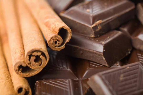 Broken pieces of chocolate and cinnamon — Stock Photo, Image
