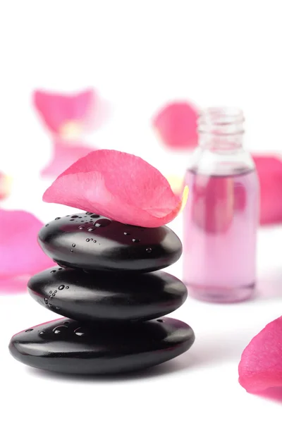 Wellness-Steine, ätherisches Öl und Rosenblätter isoliert — Stockfoto
