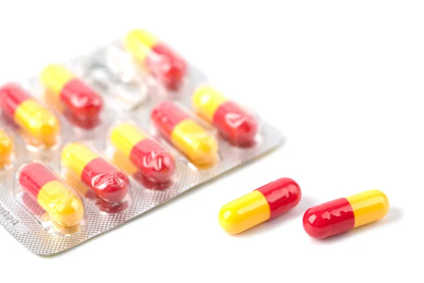 Červené a žluté tobolka pilulek v blistru, samostatný — Stock fotografie