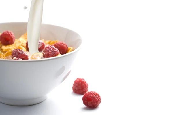 Milk pouring onto muesli with raspberry isolated — Stock Photo, Image