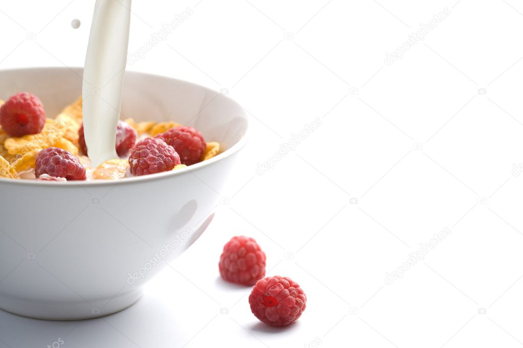 Milk pouring onto muesli with raspberry isolated