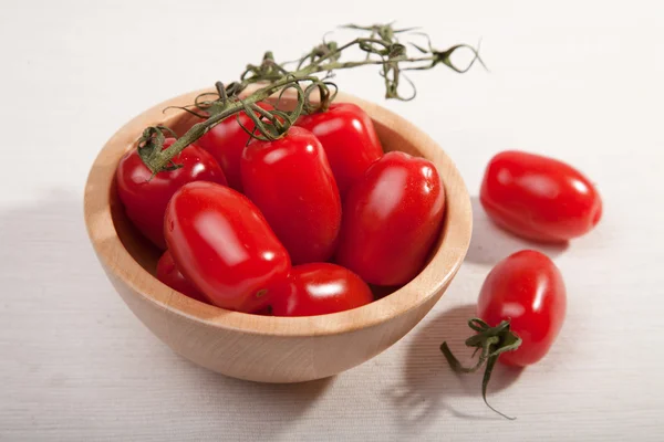 Ripe tomatoes in wooden bowl — Stock Photo, Image
