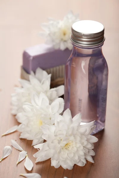 Spa y cuidado corporal - botella cosmética y flores —  Fotos de Stock