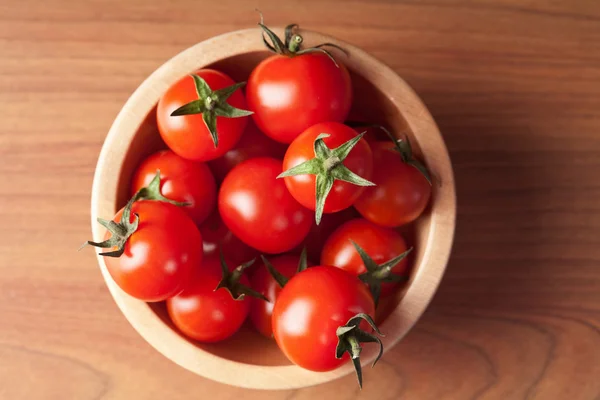Ripe tomatoes in wooden bowl — Stock Photo, Image