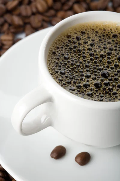 Weiße Tasse Kaffee und geröstete Bohnen — Stockfoto