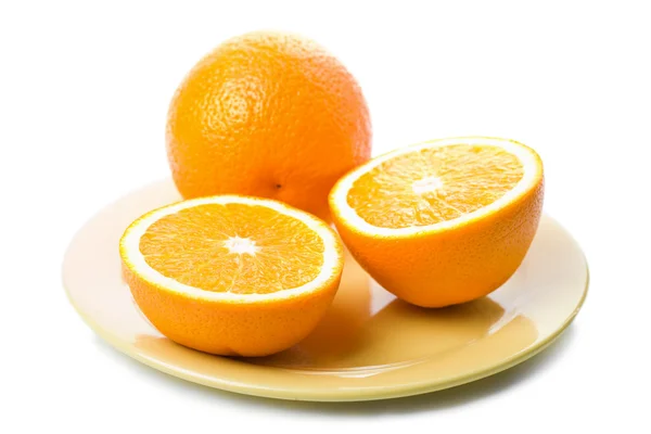 Ripe oranges in yellow plate isolated — Stock Photo, Image