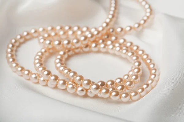 Perlový náhrdelník nad bílého hedvábí — Stock fotografie