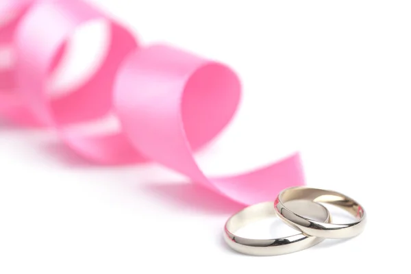 Gold wedding rings and pink ribbon isolated — Stock Photo, Image